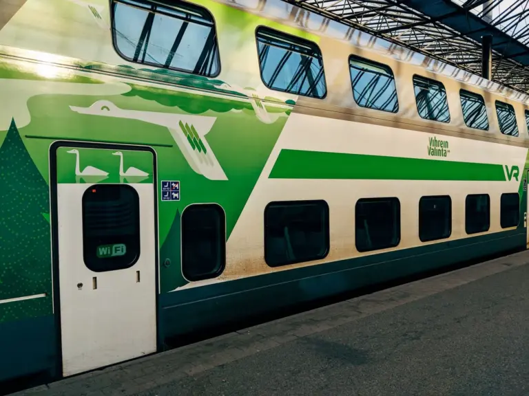 Grün-weißer finnischer Doppelstockzug am Bahnhof Helsinki