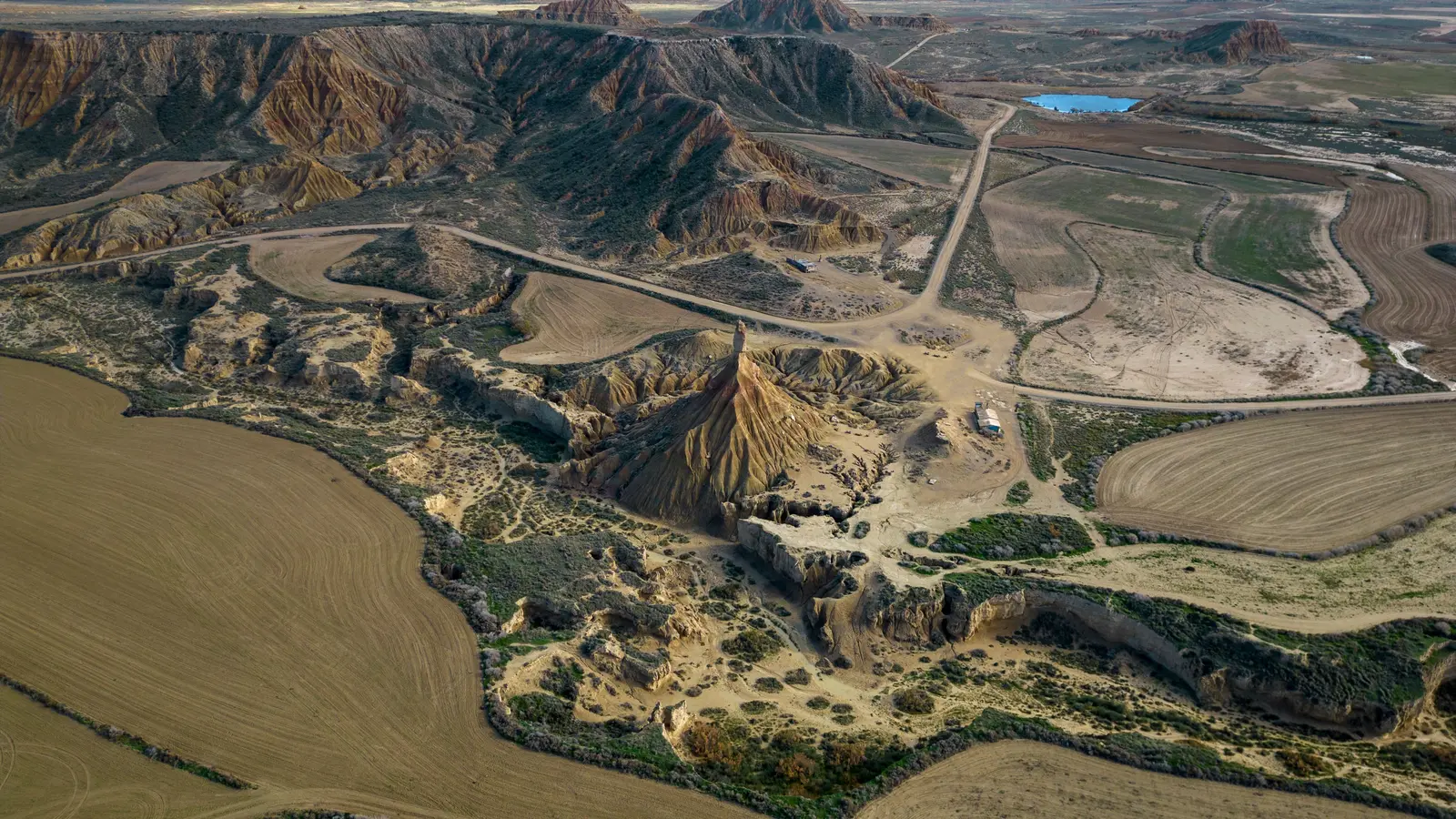 Luftbild der Erosionshügel, Felder und unbefestigten Pisten in den Bardenas Reales
