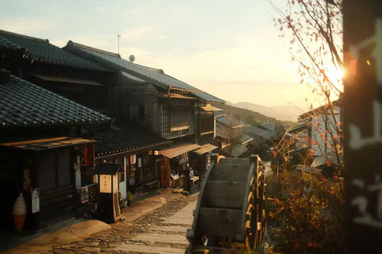 Historische Holzhäuser an der gepflasterten Hauptstraße von Magome im Abendlicht
