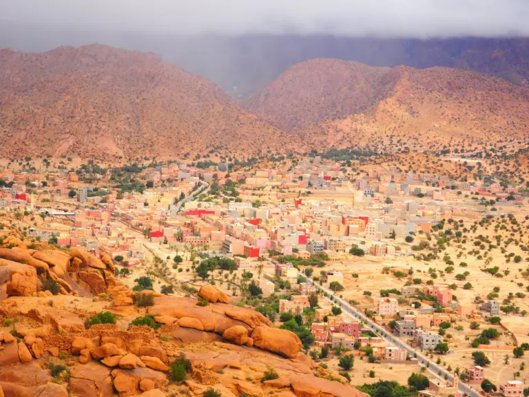 Blick über Tafraoute und seine Häuser zu den rötlichen Bergen des Anti-Atlas